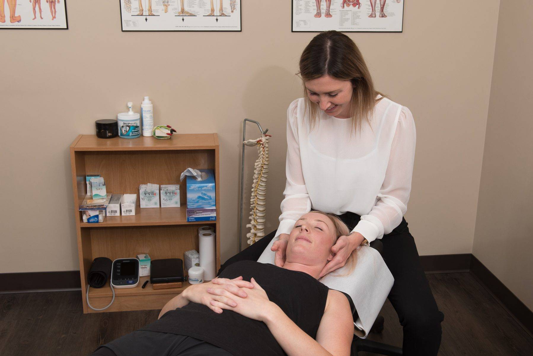 a woman is getting a massage in a chiropractic office