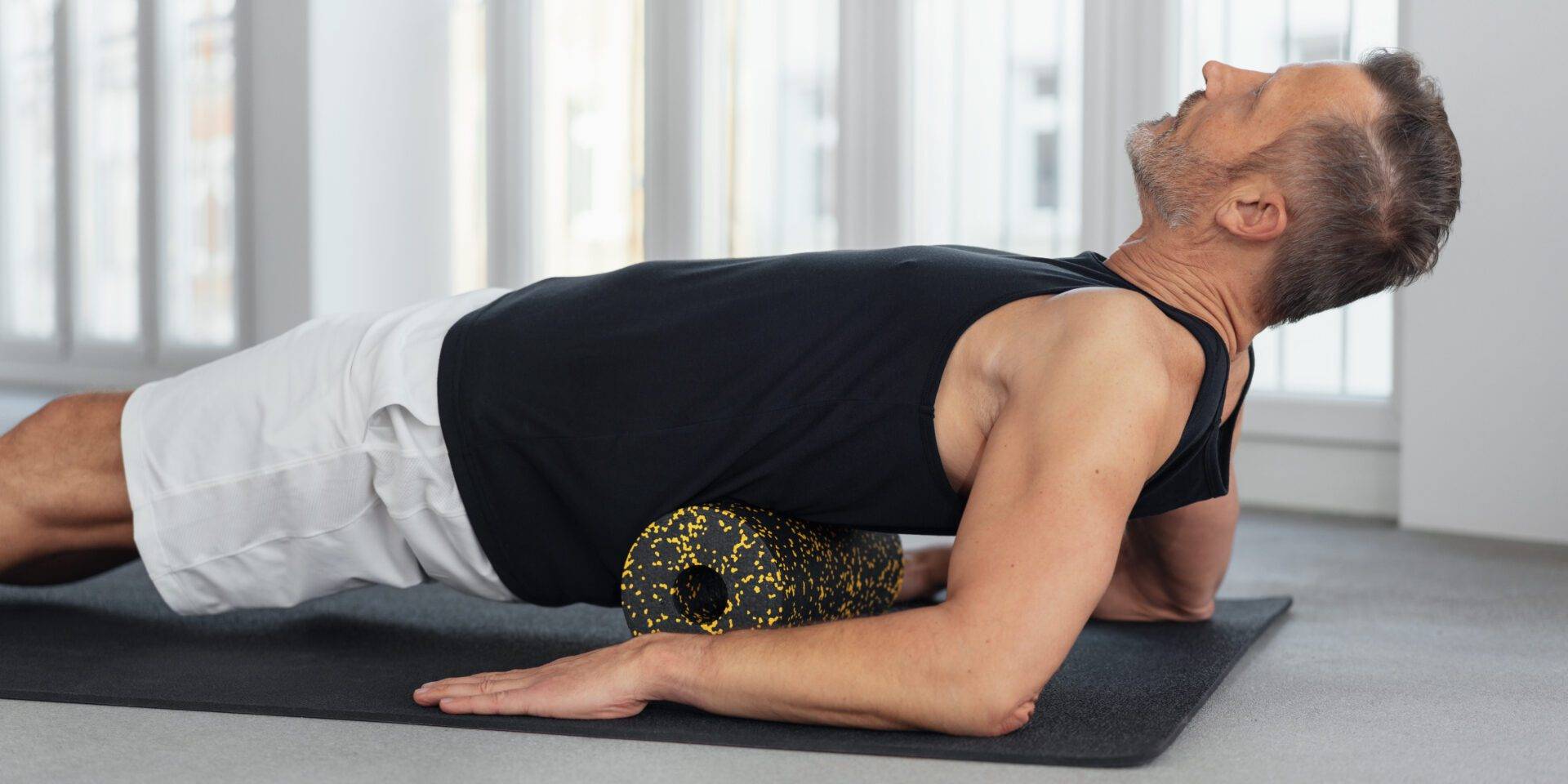 Man using a foam roller to massage his back