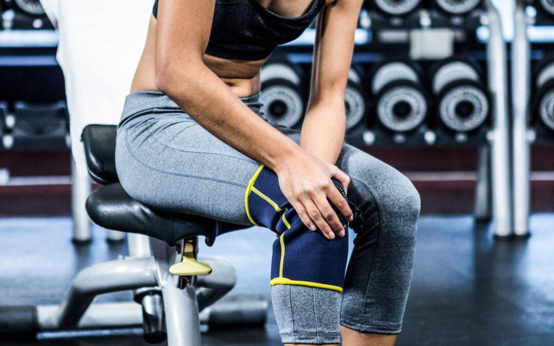 Fit woman having knees pain at gym