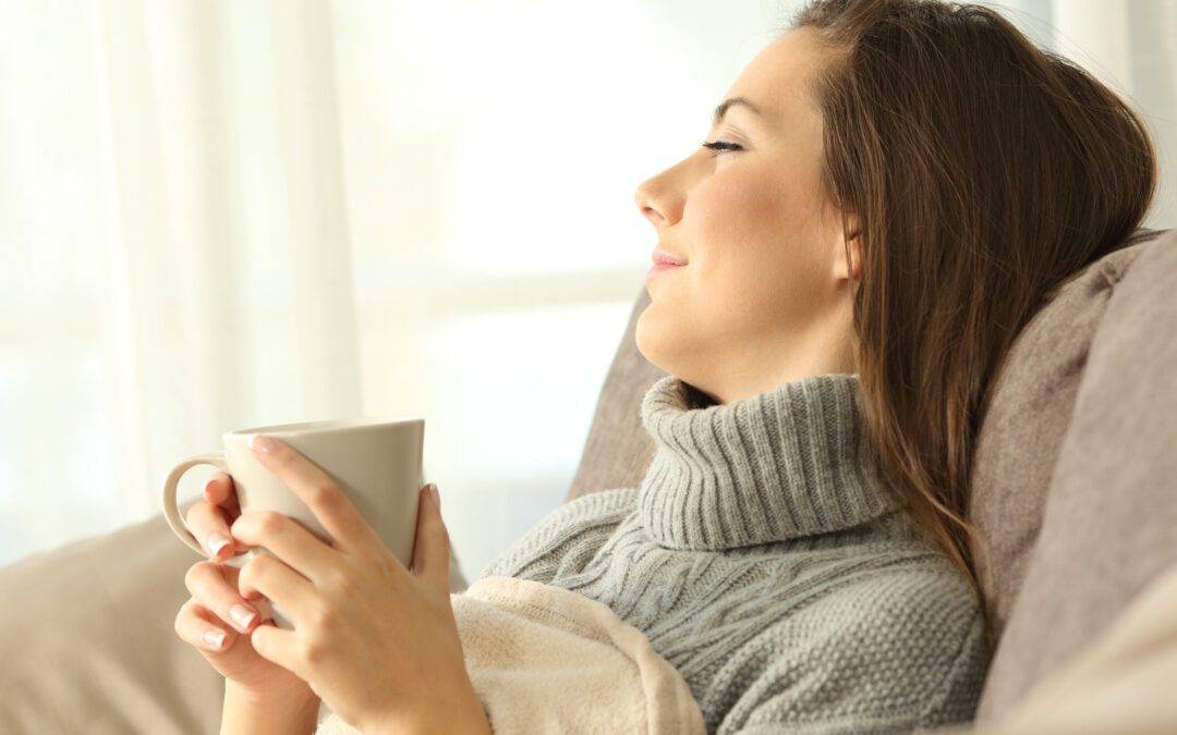 Pensive woman relaxing at home in winter