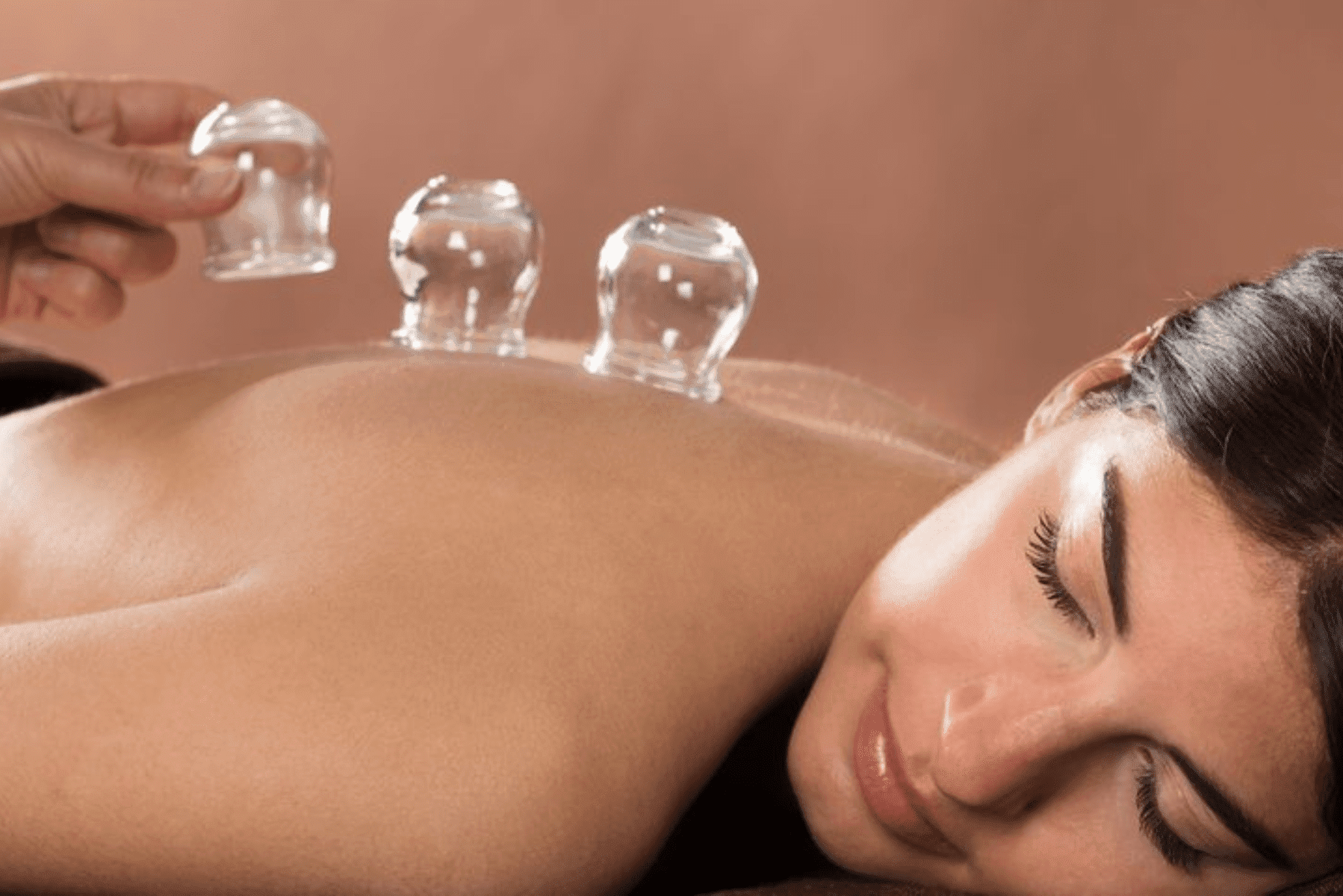 a woman getting a massage with two glass cups