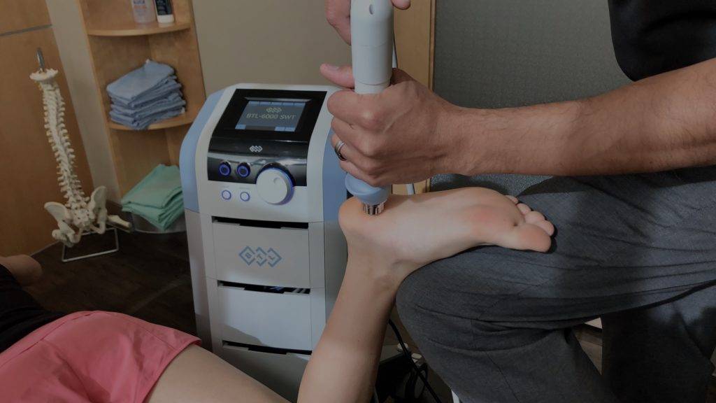a woman is getting her foot massaged by a machine