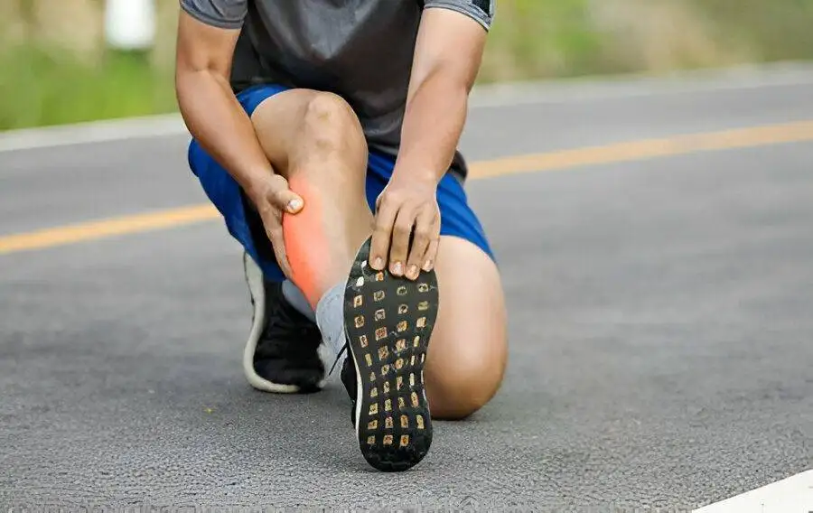 Runner holding painful calf on roadside